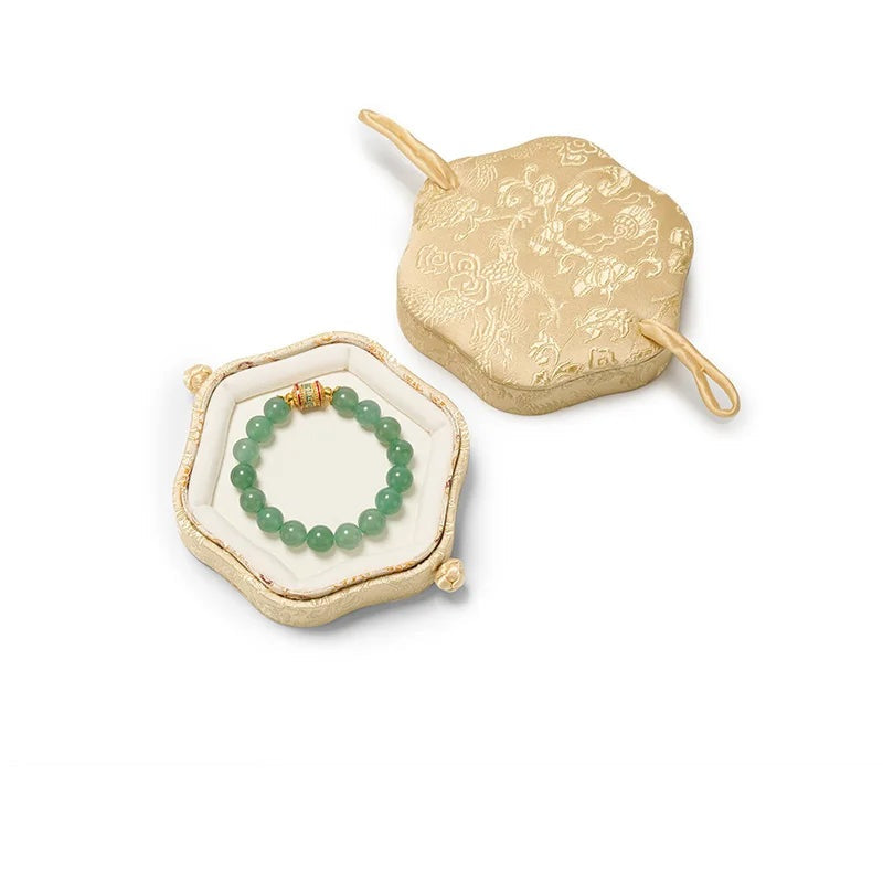 Écrin hexagonal dragon – coloris doré clair ouvert avec un bracelet sur fond blanc