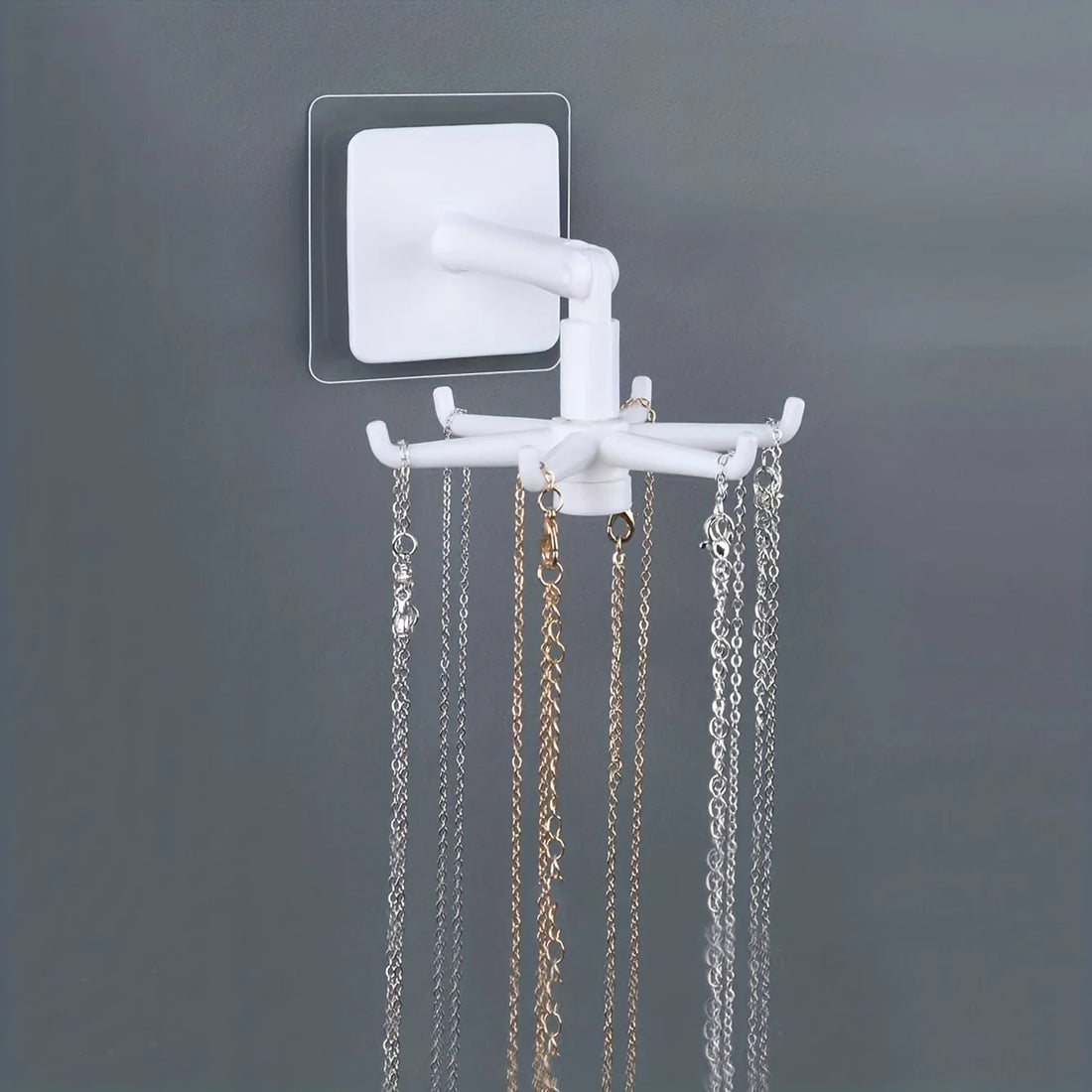 Porte bijoux mural rotatif – porte bijoux blanc avec colliers sur un mur gris