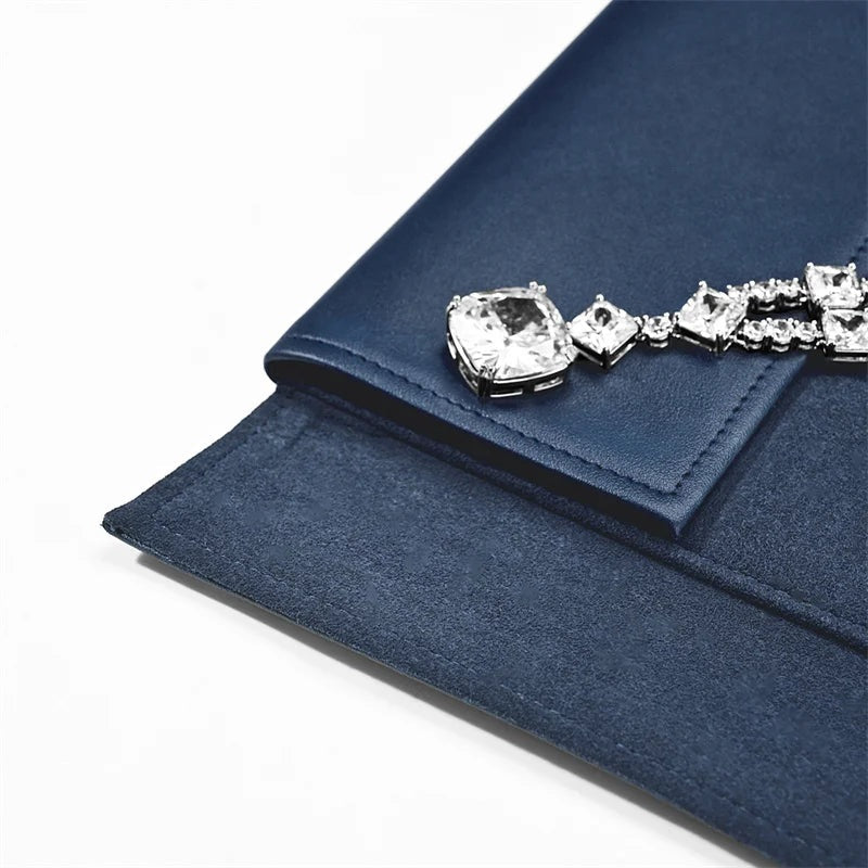 Pochette collier cuir bleu – détail de la couture et du pendentif sur le rabat