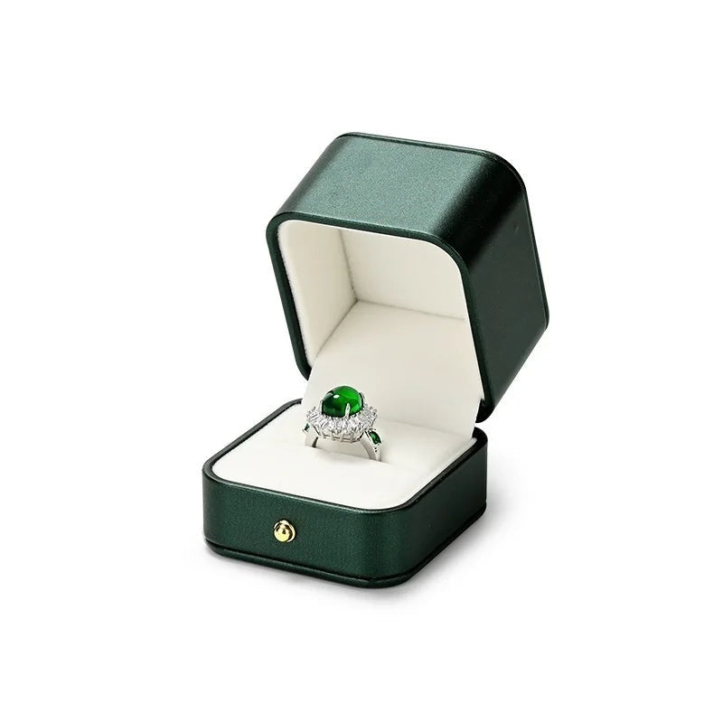 Écrin vert – écrin à bague ouvert avec une bague à pierre verte
