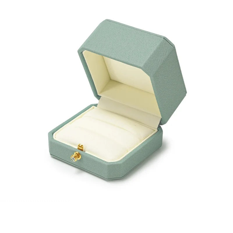 Écrin à bague vert sauge – ouvert sur le coussin crème, fond blanc