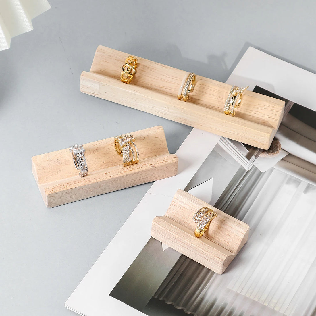 Présentoir bague bois à rainure – trois longueurs garnies de bagues, vue de trois quarts
