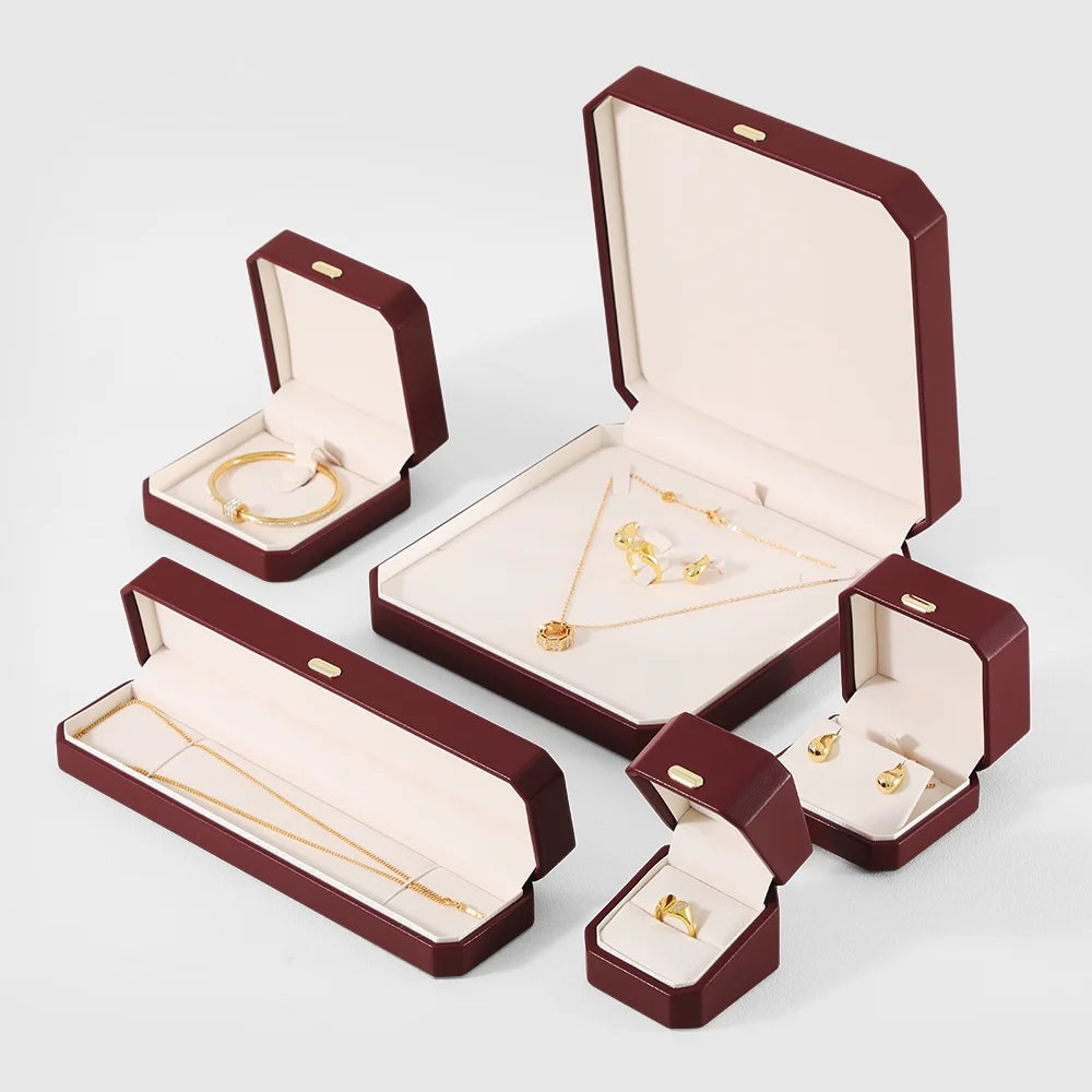 Écrin octogonal rouge bordeaux – gamme ouverte avec bague, bracelet, collier et boucles d'oreilles