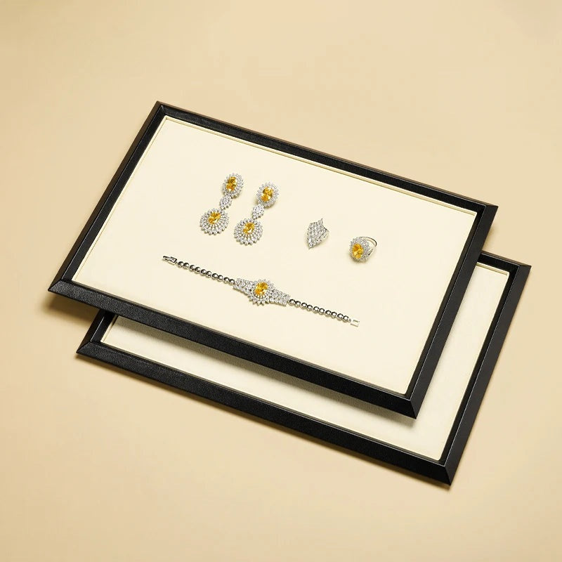 Plateau bijoux simili cuir – boucles d'oreilles, bague et bracelet sur cadre noir