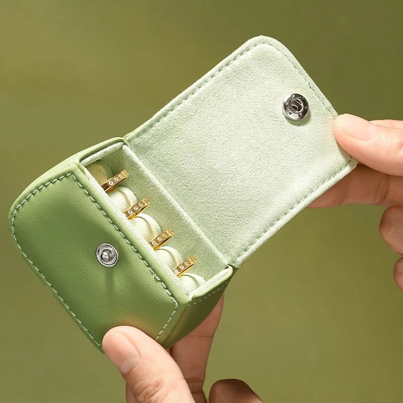 Boîte à bague de voyage en cuir vert – main tenant le coffret ouvert sur ses fentes à bagues