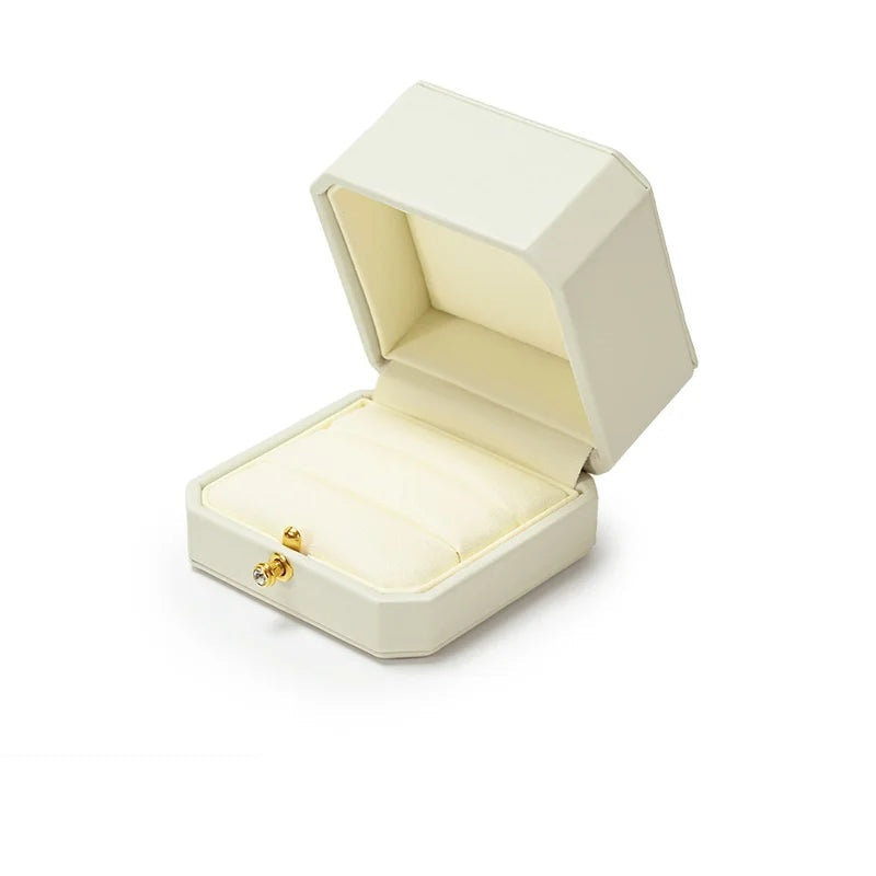 Écrin à bague blanc – ouvert sur le coussin crème, fond blanc