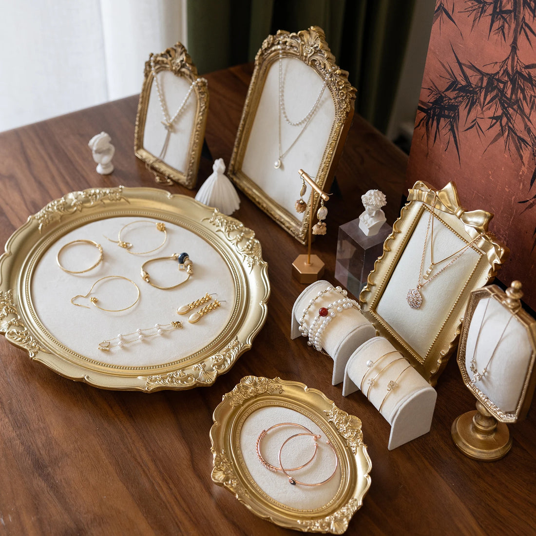 Présentoir bijoux baroque doré – cadres et plateaux dorés présentant colliers et bagues