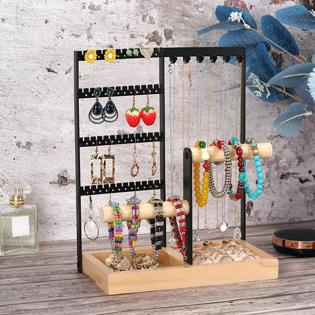 Présentoir bijoux bois et métal noir – en situation devant un mur, avec boucles, colliers et bracelets