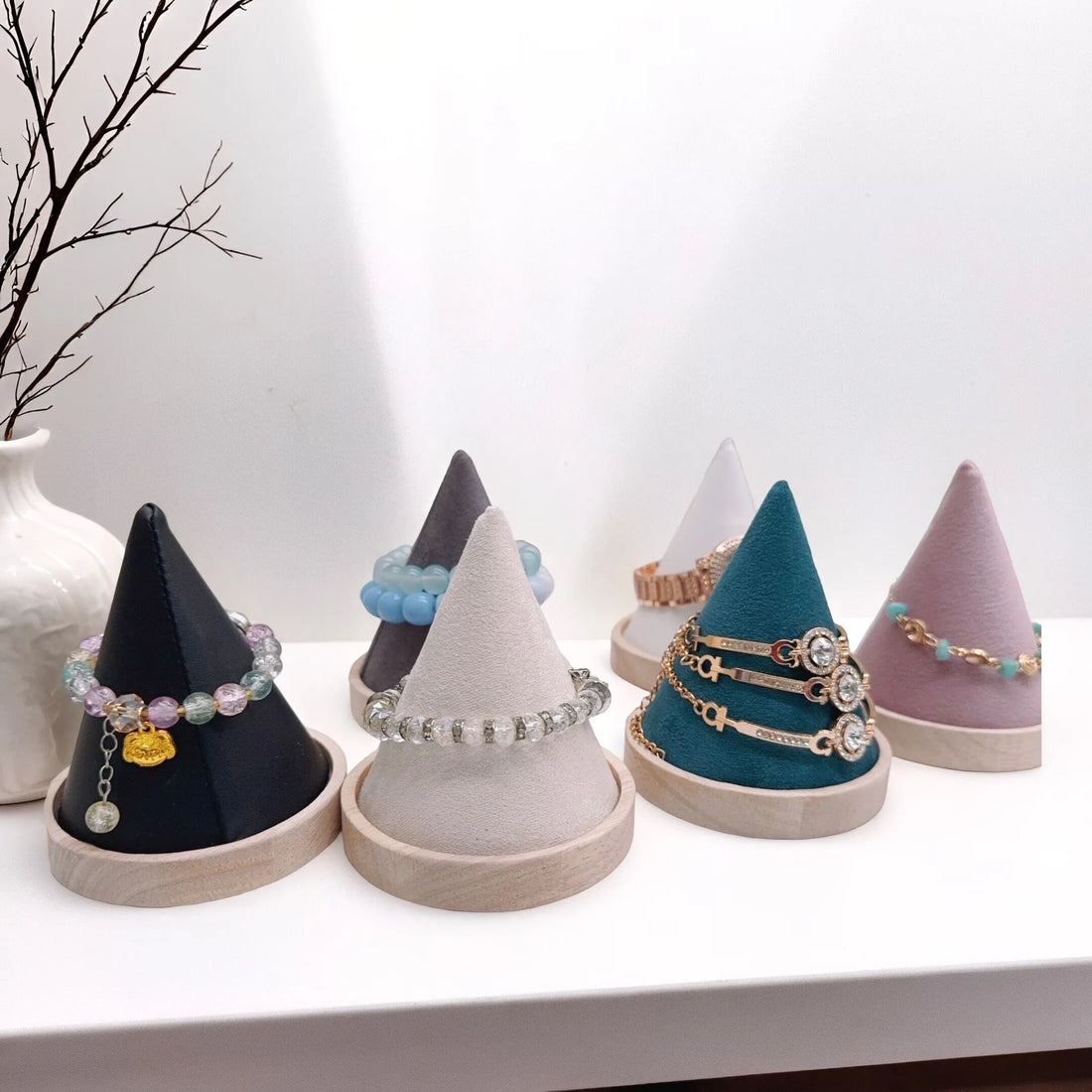 Présentoir bracelet cône à socle bois – cônes de teintes différentes avec bracelets en vitrine