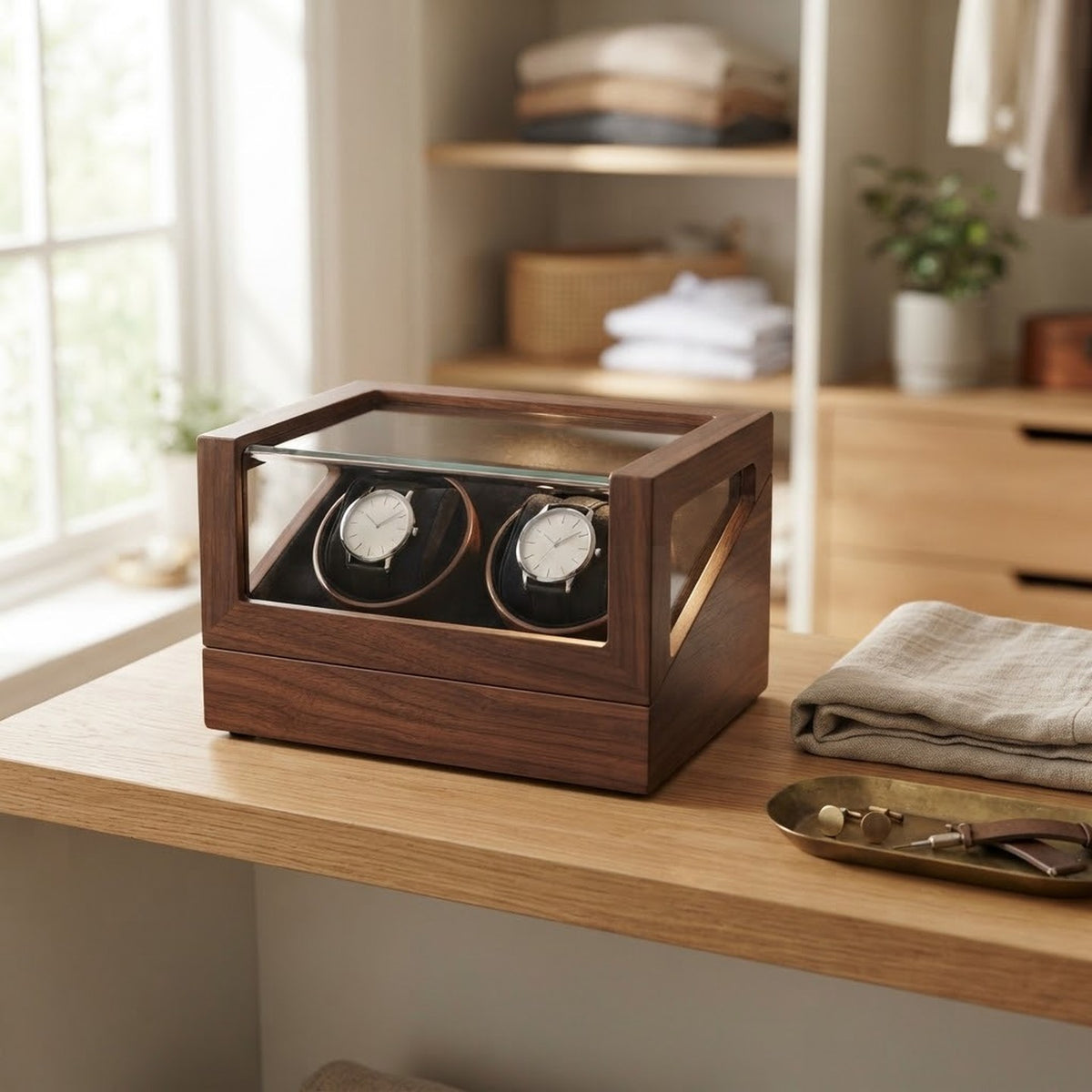 Remontoir en bois à couvercle vitré sur une étagère de dressing, avec deux montres